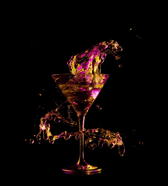 Cocktail in glass with splashes on dark background. Party club entertainment. Mixed light. — Stok Foto