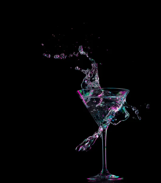 Cocktail in glass with splashes on dark background. Party club entertainment. Mixed light. — Stock Photo, Image