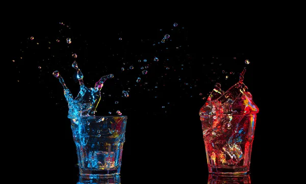 Cocktail in glass with splashes on dark background. Party club entertainment. Mixed light. — Stock Photo, Image