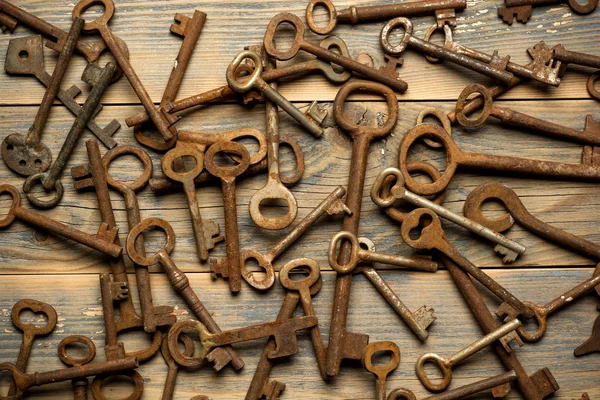 Muchas viejas claves en un escritorio de madera bien usado — Foto de Stock