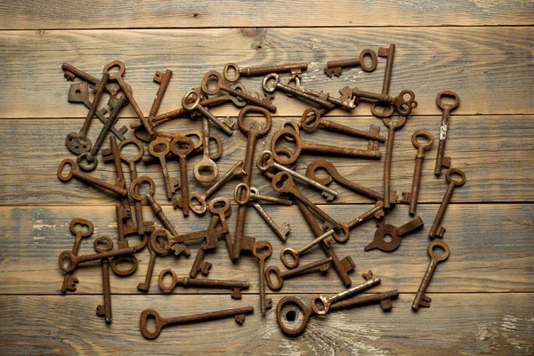 Многие старые ключи на хорошо использовать деревянный стол — стоковое фото