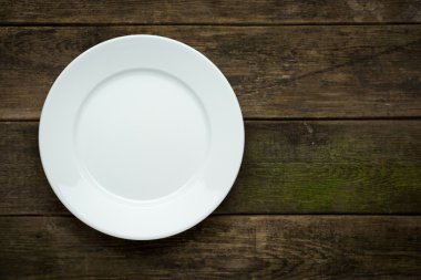 Ahşap zemin üzerinde boş beyaz tabak