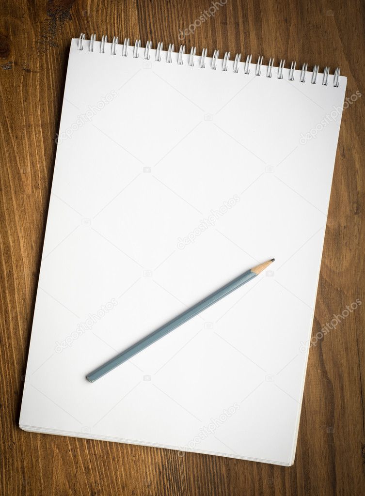 notebook with pencile on a wood