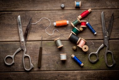 Vintage dikiş araçlarını ve renkli bant ile arka plan. dikiş takımı. makas, bobin iplik ve iğne üzerindeki eski ahşap arka plan ile