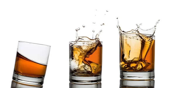 Whiskey glasses with splash, isolated on white — Stock Photo, Image