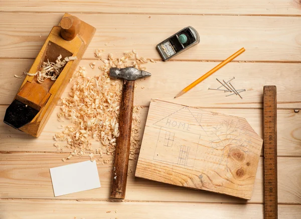 Herramientas de carpintería en el fondo de la tabla de madera con tarjeta de visita —  Fotos de Stock