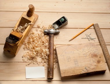 marangoz araçları, çekiç, metre, çivi, talaş ve uçağı ele ahşap masa