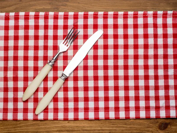Cuchillo y el tenedor en la servilleta sobre madera —  Fotos de Stock