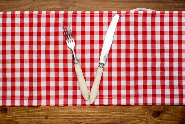 Cuchillo y el tenedor en la servilleta sobre madera —  Fotos de Stock