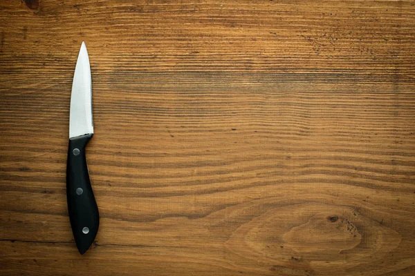 Kitchen knife over brown wooden table — Stock Photo, Image