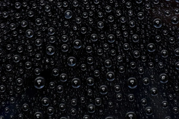 Gouttes d'eau sur surface noire — Photo