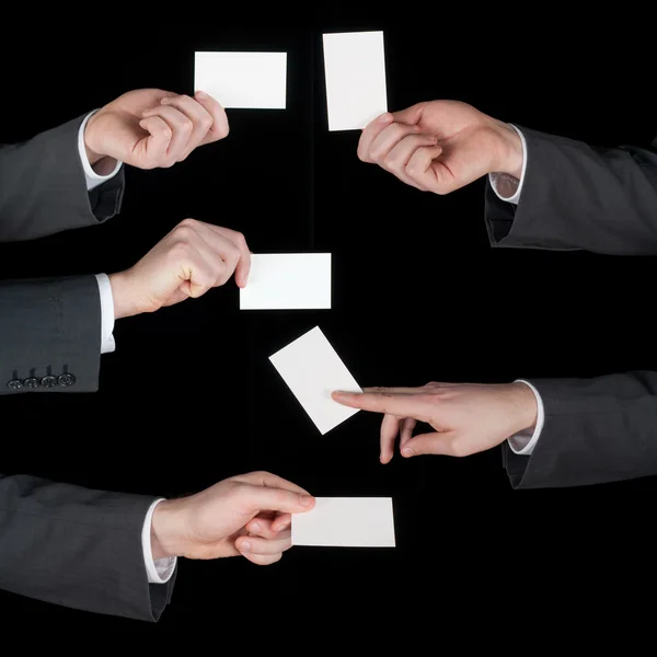 Hands hold business cards collage on black — Stock Photo, Image