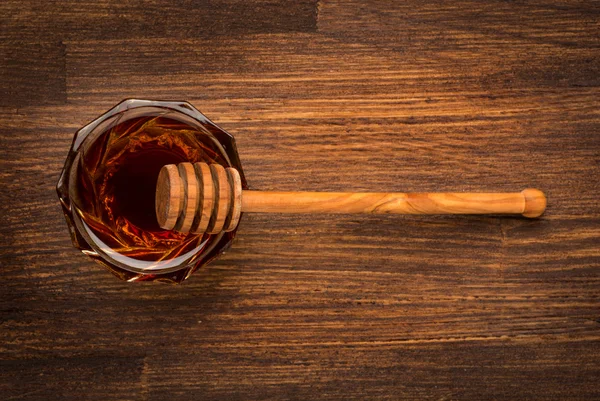 Fresh natural honey in a jar with honey spoon on a wooden rustic vintage background — Stock Photo, Image