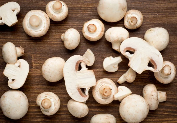 Fresh whole white button mushrooms, or agaricus, on a rustic wooden counter ready to be cleaned and washed for dinner — Stock Photo, Image