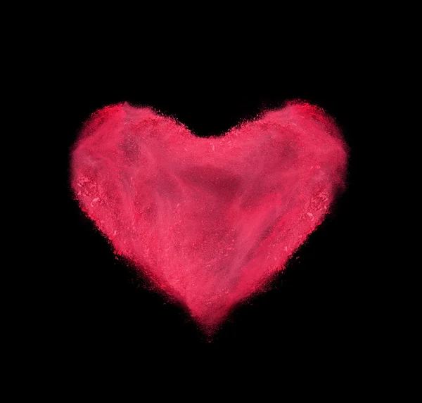 Heart made of red powder explosion on black background — Stock Photo, Image