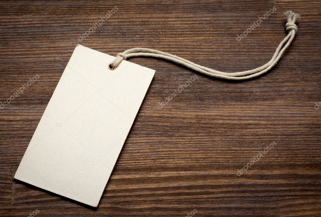the blank price tag label on wooden background close up