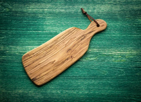 Composition with olive wood board on top of oak table, rustic background. Top view. — Stock Photo, Image