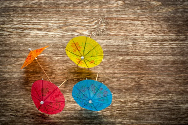 Kleurrijke cocktail paraplu's liggend op een houten backdround, conceptuele voor feesten en festiviteiten — Stockfoto