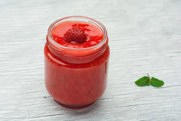 Copo de smoothie de morango em um fundo de madeira — Fotografia de Stock