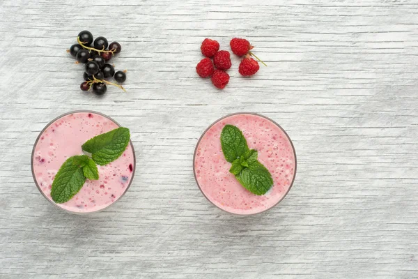 Φρέσκο γάλα, σταφίδα, βατόμουρο και κόκκινη σταφίδα ποτά στο τραπέζι wodeen, ανάμικτες πρωτεΐνη κοκτέιλ με φρέσκα φρούτα — Φωτογραφία Αρχείου