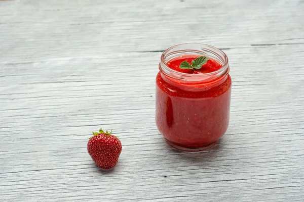 Verre de smoothie aux fraises sur fond bois — Photo