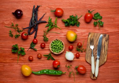 Bıçak ve çatal ile beyaz bir plaka üzerinde taze organik sebze. Yatay kompozisyon