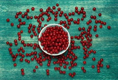 Kirazlar ahşap masada, su damlaları makro arka planda.