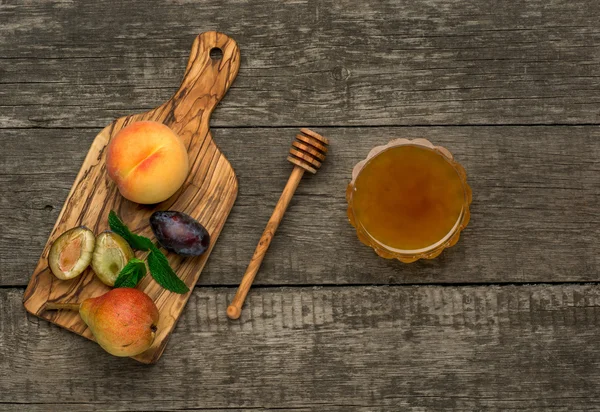 Fruits mûrs de pêche, prunes et poires au miel dans un plateau. — Photo