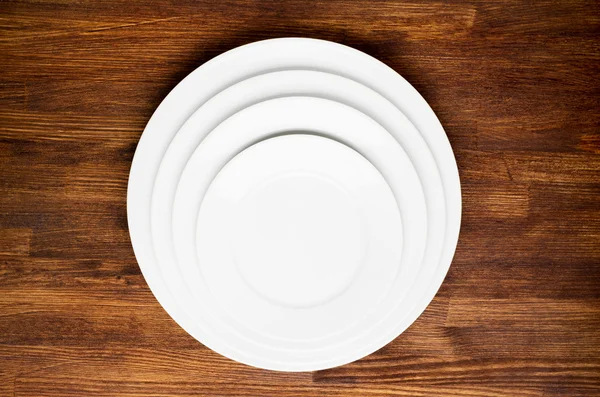 Üres fehér tányérok a fa asztalon — Stock Fotó