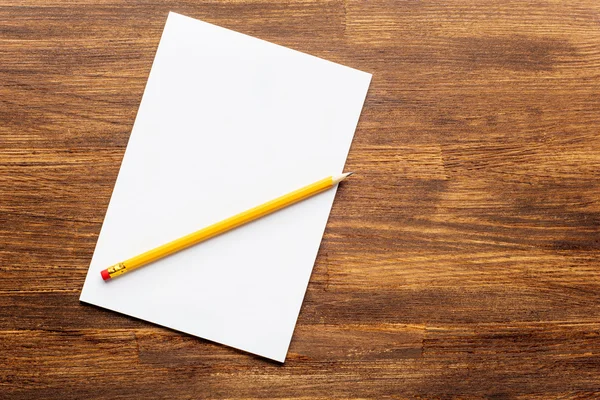 Cuaderno con lápiz en un escritorio de madera . — Foto de Stock