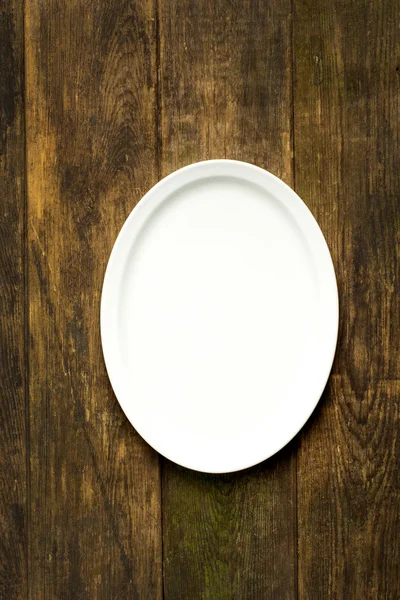 Empty white plate on wooden table — Stock Photo, Image