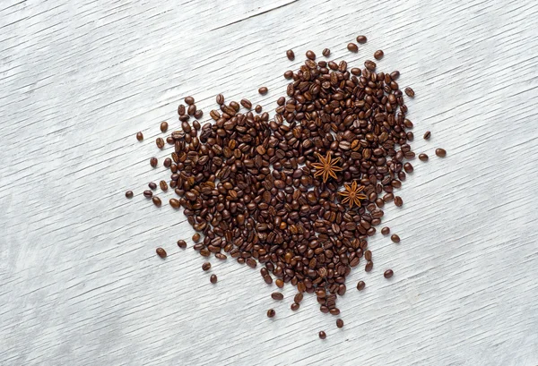 Forma do coração feito de grãos de café no fundo de madeira — Fotografia de Stock