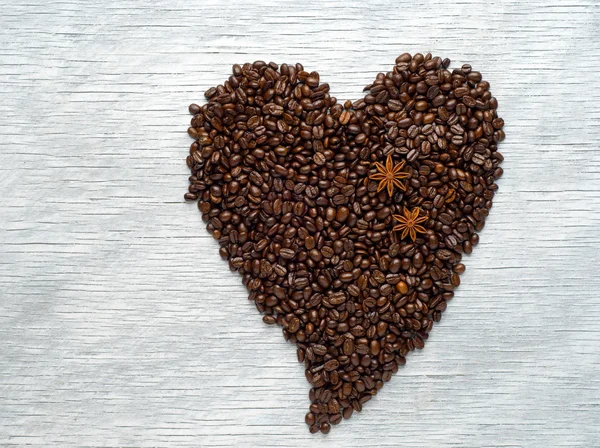 Forma de corazón hecha de granos de café sobre fondo de madera — Foto de Stock