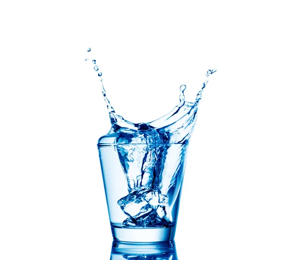 Isbitar stänk i glas vatten, isolerad på vit — Stockfoto