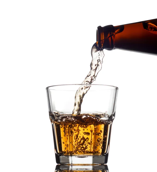 Wylewanie whisky w przezroczystego szkła, na białym tle — Zdjęcie stockowe