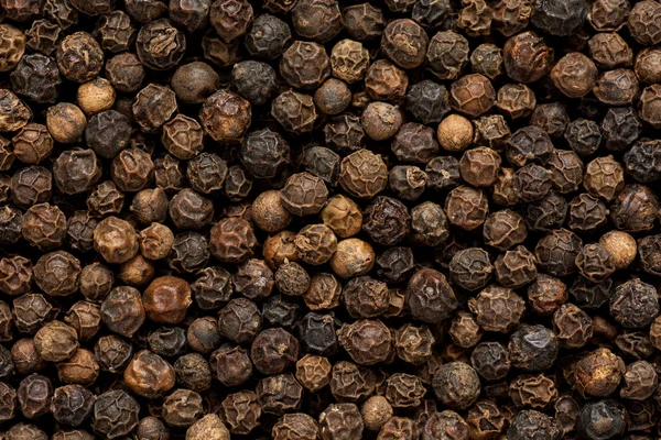 Grãos de pimenta preta como fundo close-up — Fotografia de Stock