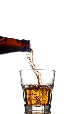 Beyaz arka plan üzerine açık bir bardak viski dökme
