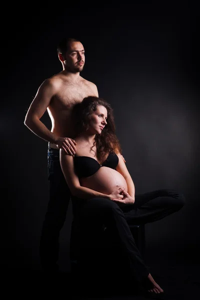 Handsome young man embracing his beautiful pregnant wife — Stock Photo, Image