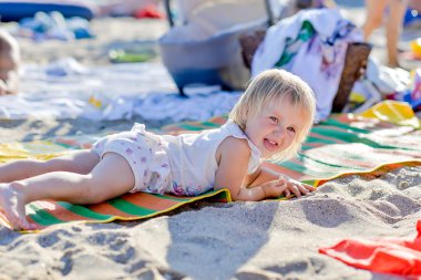 küçük sarışın kız sahilde yalan söylüyor