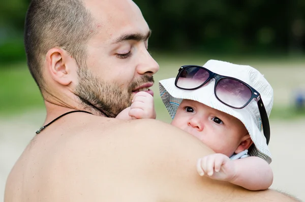 彼の父の肩の上に座って太陽からメガネで愛らしい幼児 — ストック写真