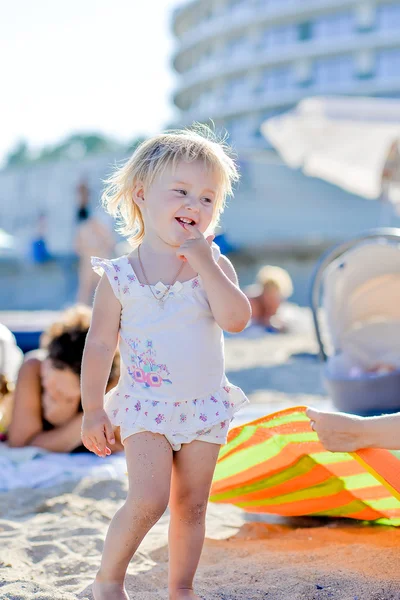 Rubia niña en la playa de pie en la arena — Foto de Stock