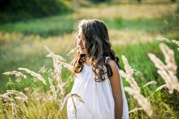 Prachtige kleuter meisje met lang blond haar reist in kleurrijke geel veld — Stockfoto