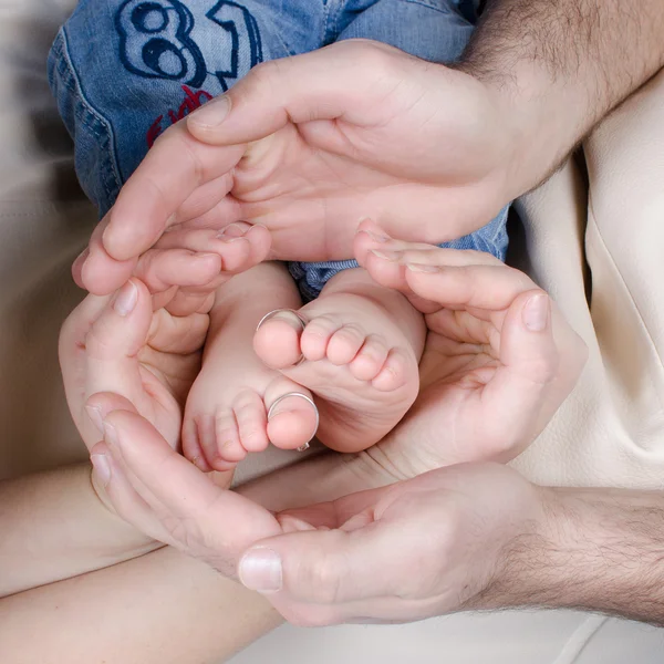 Recém-nascido bebê pés pais segurando em mãos.Mãe e pai segurar bebê pernas . — Fotografia de Stock