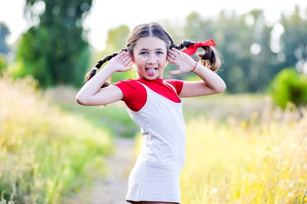 Chica con coletas imagina el verano en la naturaleza — Foto de Stock