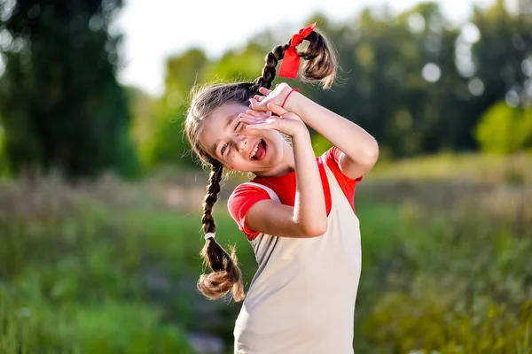 Chica con coletas imagina el verano en la naturaleza — Foto de Stock