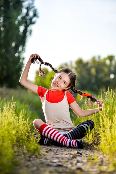 Chica con coletas imagina el verano en la naturaleza — Foto de Stock