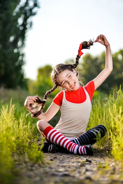 Девушка с косичками представляет лето на природе — стоковое фото