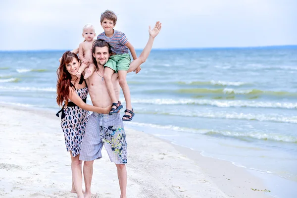 Familia feliz divirtiéndose en la playa — Foto de Stock