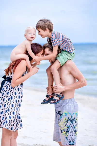 Familia feliz divirtiéndose en la playa — Foto de Stock