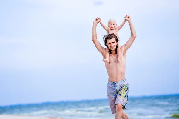 Padre e hijo jugando en la playa durante el día . — Foto de Stock